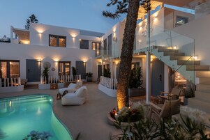 Una casa moderna con piscina, area salotto esterna e una scala.
