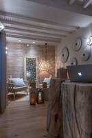 Un interno moderno con parquet, un computer portatile su un ceppo d'albero e una parete con decorazioni circolari.