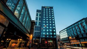 Un edificio moderno con un evidente cartello 'Motel One', ampie finestre e un ingresso ben visibile.