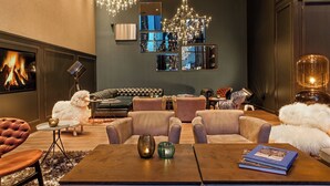 Un soggiorno moderno con camino, sedute confortevoli e specchi decorativi.