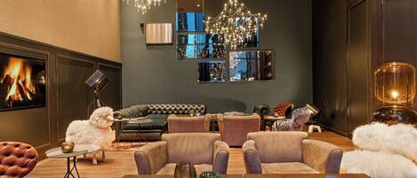 Una sala de estar moderna con chimenea, asientos cómodos y espejos decorativos.