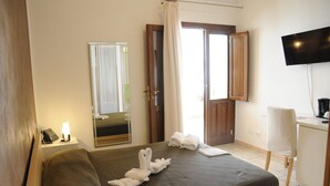 A hotel room with a bed, a desk, a television, and a mirror. - Zefiro Rooms & Breakfast (San Vito Lo Capo)