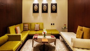 A living room with a sofa, a coffee table, and a bed. - Sahara Star (Mumbai)