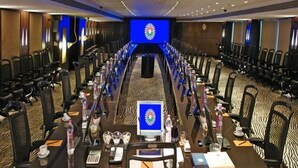 A conference room with a long table, chairs, and a large screen at the front. - Sahara Star (Mumbai)