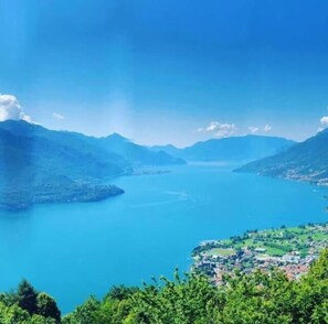A panoramic view of a lake surrounded by mountains, with a town visible in the foreground. - B&B Lake Como Cottage (Lecco)
