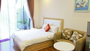 Una habitación de hotel con una cama, un sofá, una mesita y un cuadro en la pared.