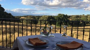 A table set outdoors with a scenic view of trees and fields.