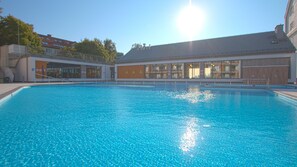 Una piscina cubierta, una piscina al aire libre de temporada, sombrillas