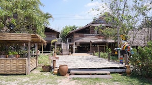 A rustic wooden building with a staircase leading to a porch. - Phuruarounmai Resort (Phu Ruea)