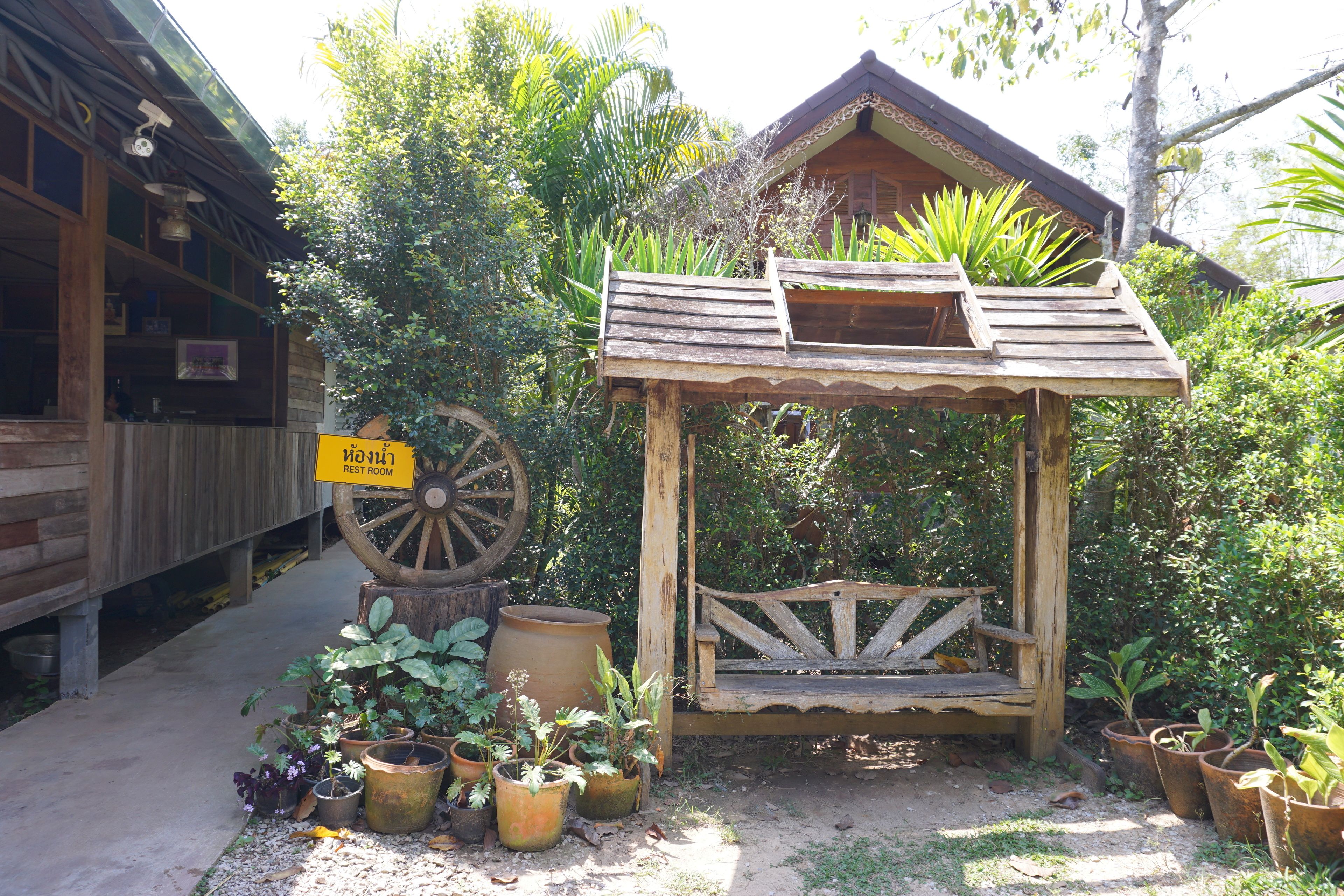 A rustic wooden structure with a porch and a sign indicating a rest room.