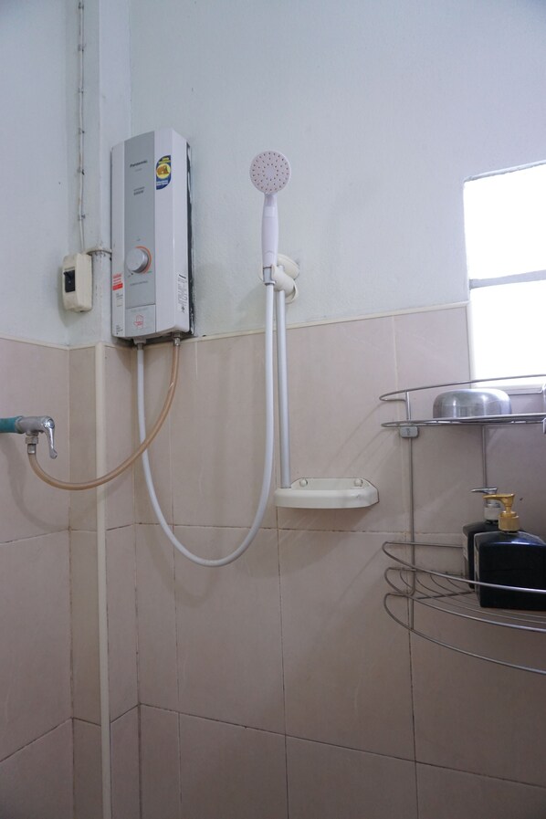A bathroom with a shower, a toilet, and a sink.