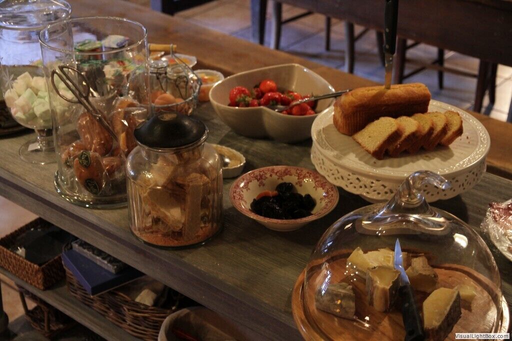 A buffet table with various food items including bread, fruits, and desserts.