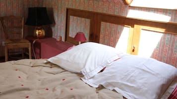 Une chambre à coucher avec un lit, une chaise, une table et une lampe.