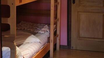 A bunk bed room with a wooden door and a notice on it.
