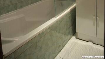 Un baño con bañera, lavamanos y espejo.