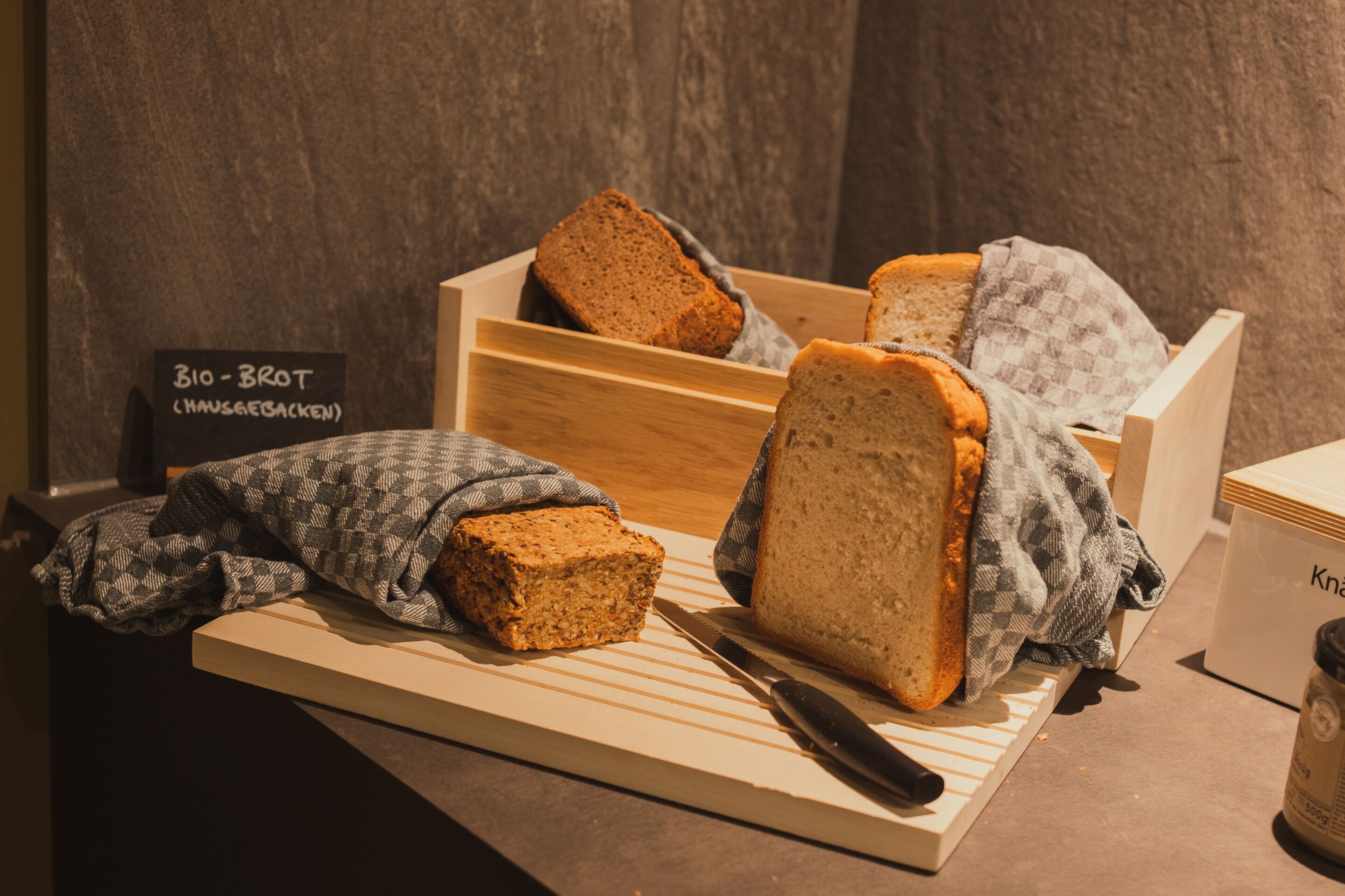A wooden cutting board with a loaf of bread and a knife.