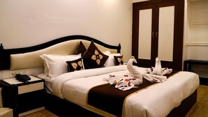 Una habitación de hotel con cama, mesita de noche, teléfono y armario.