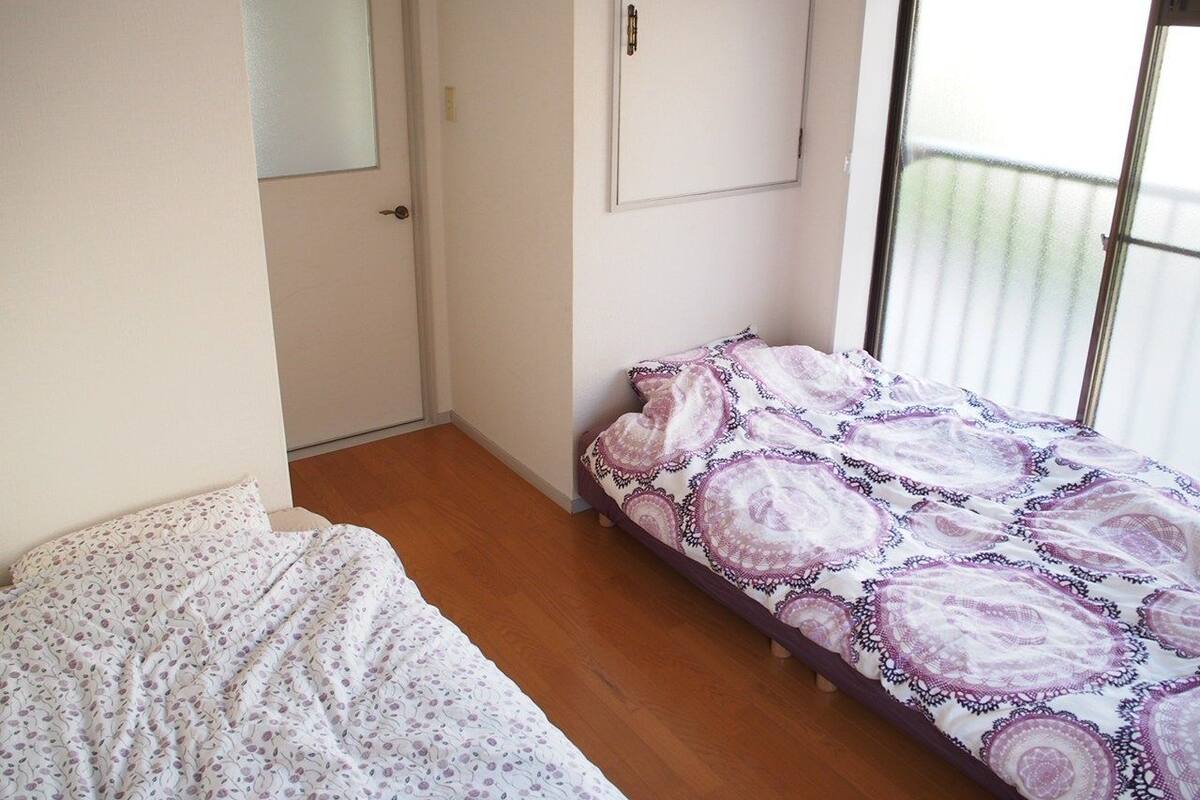 A bedroom with a bed, a window, and a door.