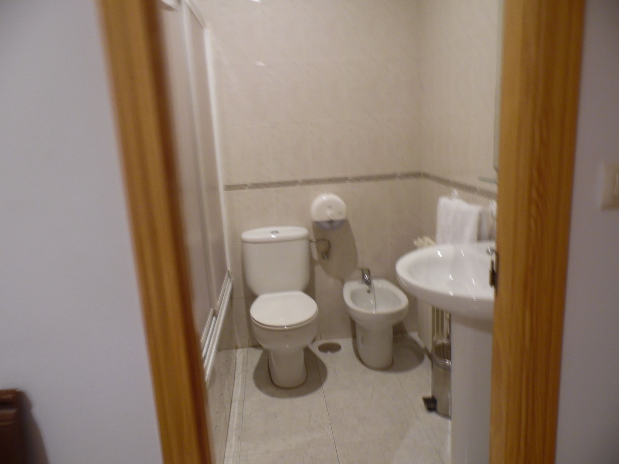 Un baño pequeño con inodoro, bidé y lavamanos.