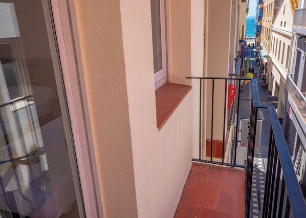 A narrow corridor with a small window and a metal railing. - AGI Gloria Rooms (Roses)