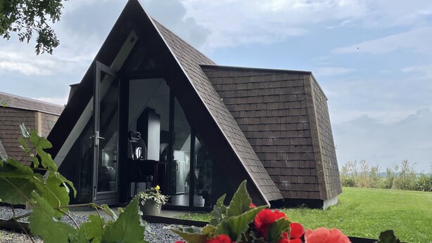 A modern building with a triangular roof and large glass windows. - Restinn Medemblik (Wieringerwerf)