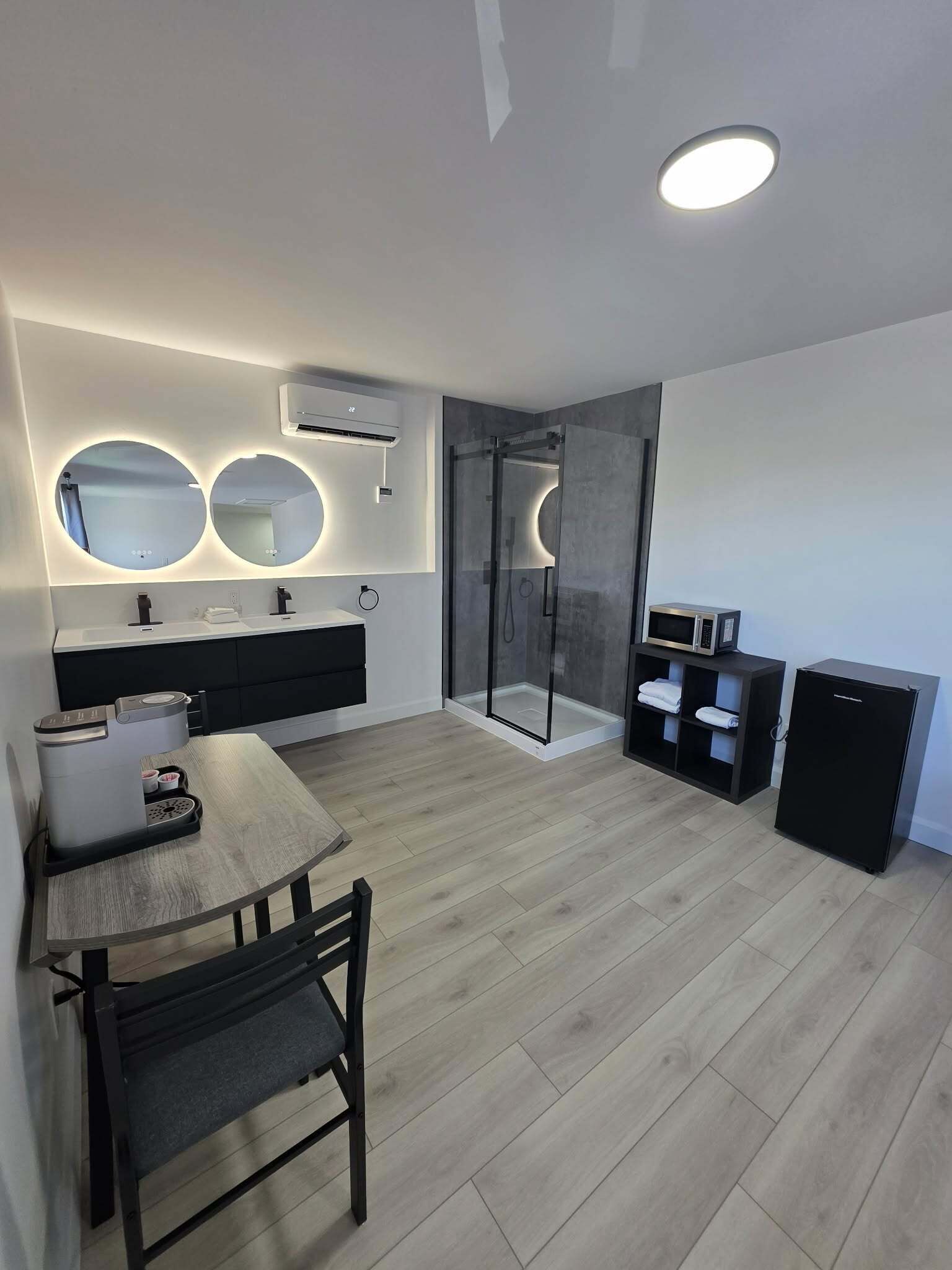 A modern kitchen with a dining table, a built-in oven, and a microwave.