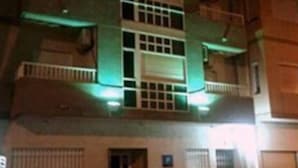 Un edificio de varios pisos con una entrada central y una puerta visible.