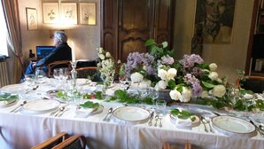 A formal dining table set with white tablecloth, plates, cutlery, and floral centerpieces. - Domaine Mongiron (Nerigean)
