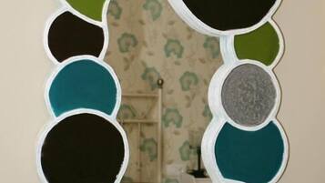 A wall-mounted mirror with a unique, abstract design featuring multiple circular segments in various colors.