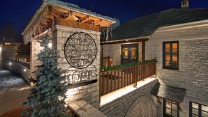 A stone building with a wooden balcony and a Christmas tree. - Kores Boutique Hotel & Spa (Zagori)