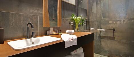 A modern bathroom with a large mirror, a sink, and a shower area.