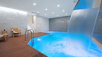 Una piscina techada, sillones reclinables de piscina