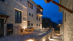 A stone building with a balcony, outdoor seating, and stone steps. - Kores Boutique Hotel & Spa (Zagori)
