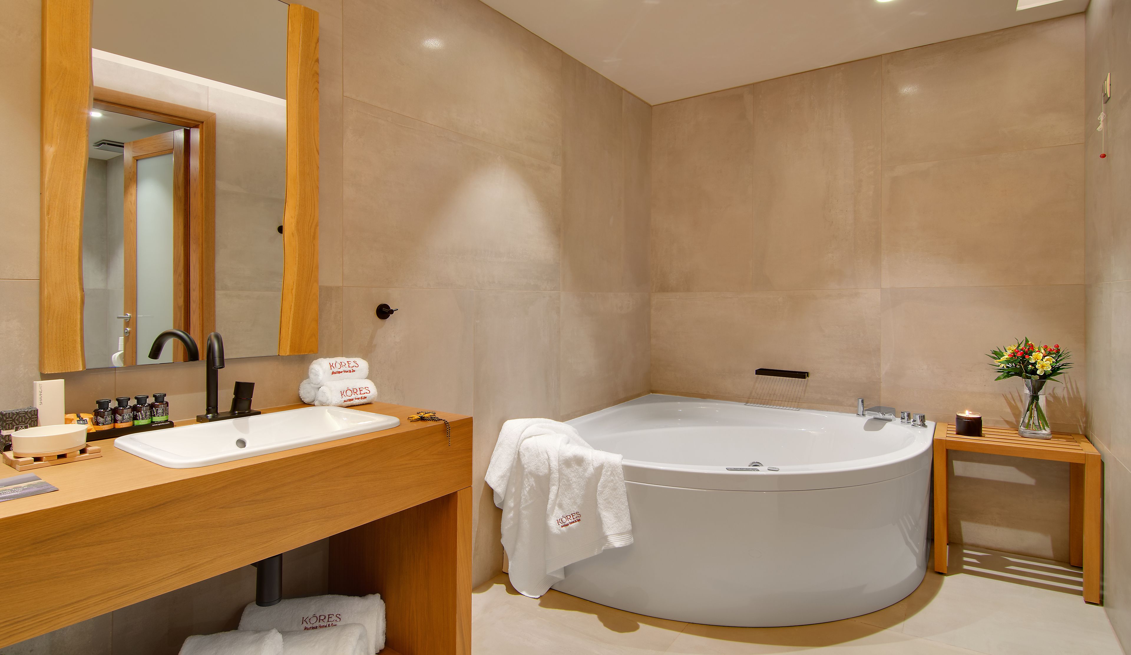 A modern bathroom with a freestanding bathtub, a wooden vanity, and a mirror above the sink.
