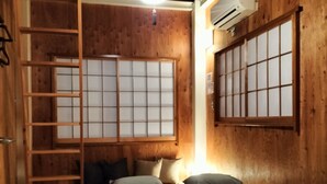 A wooden room with a bed, a ladder, a window with shoji screens, and an air conditioning unit. - Vacation house Secretbase (Tokyo)