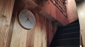 A wooden staircase with a clock on the wall. - Vacation house Secretbase (Tokyo)