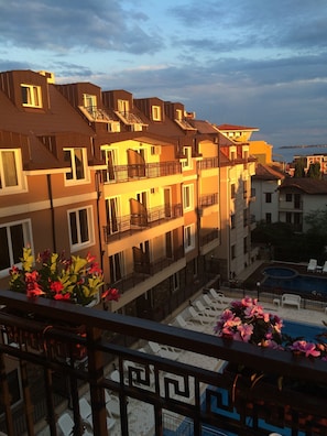 A multi-story hotel with balconies, a swimming pool, and flower arrangements. - Horizont Apartments (Sunny Beach)