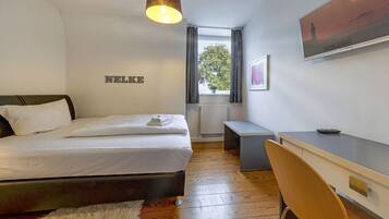 A modern bedroom with a bed, a desk, and a chair.