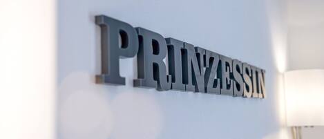 A metallic sign with the word "PRINZESSIN" on a wall.