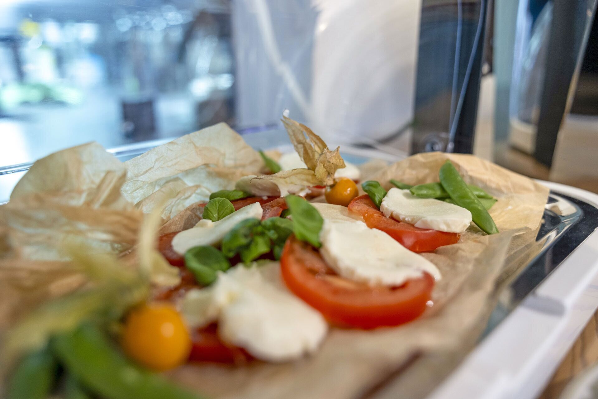 A close-up of a fresh salad with tomatoes, mozzarella, and basil on a plate.