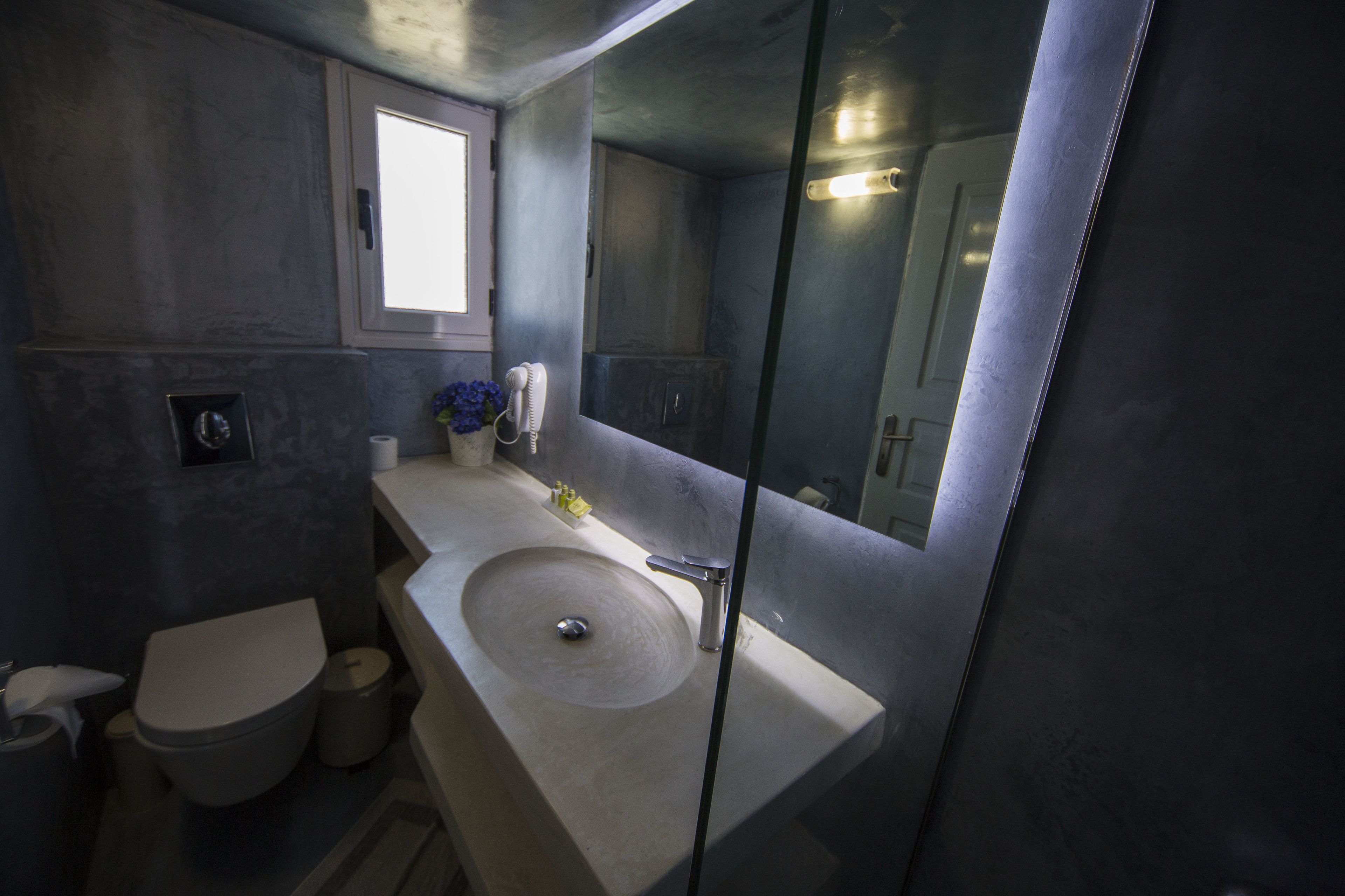 Een badkamer met een wastafel, toilet en spiegel.