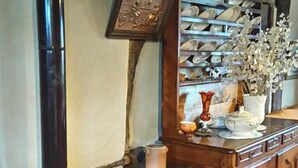 Cuina amb fogó antic, armaris de fusta i escorredís de plats.