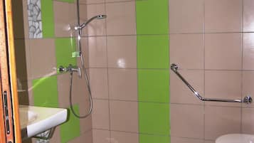 Une salle de bain avec une douche, des toilettes et un lavabo.