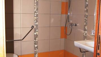 A bathroom with a shower, toilet, and sink.