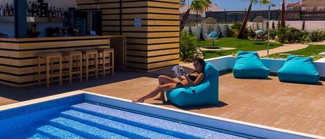 A poolside area with a bar, seating, and a view of the pool.