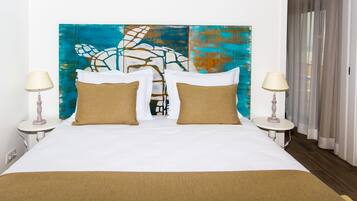 A hotel room with a large bed, two bedside tables, and a colorful abstract painting on the wall.