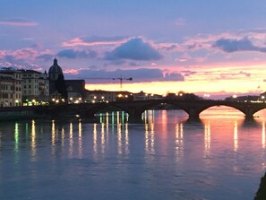 A bridge over a body of water with buildings on either side. - Le stanze degli amidei (Florence)