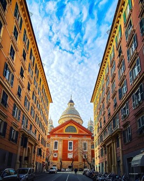 A street view with a prominent building featuring a large dome and a red facade. - Virginia's Rooms (Genoa)