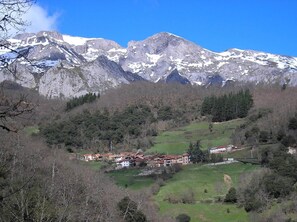 A mountainous landscape with a village nestled among the hills. - Casa Reda - Posada de Viñón (Cillorigo de Liebana)