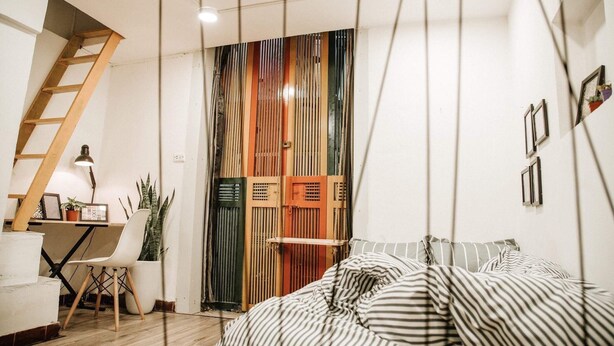 A bedroom with a bed, a desk, a chair, and a ladder. - Michi (Hanoi)